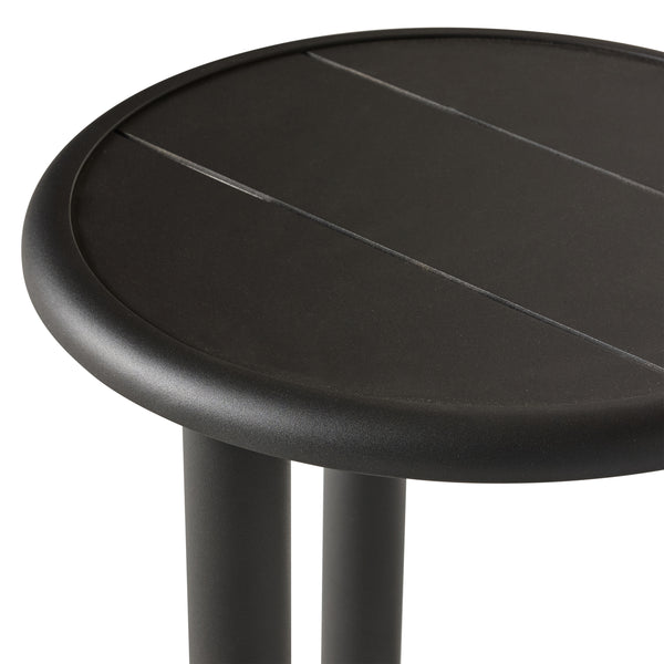 A close up of Stinson Side Table in Aluminum by Terra Outdoor Living — features a powdercoated aluminum frame in a charcoal finish with a slatted top that allows water to drain; compact tabletop provides space for a drink and a book, perfect for pairing with Stinson seating components.